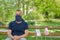 Man wearing a face guard seated on a park bench