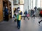 A man wearing a face mask and uniform distributes newspapers to people exiting the doors of a subway station