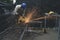 Man wearing hat, mask and glove using electric steel cutter machine