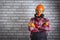 Man wearing helmet, gloves glasses, protective gear near brick wall with copy space.