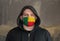 Man Wearing a hood and a Benin flag Mask to Protect him virus