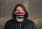 Man Wearing a hood and a Gambia flag Mask to Protect him virus