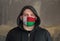 Man Wearing a hood and a Madagascar flag Mask to Protect him virus