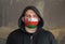 Man Wearing a hood and a Oman flag Mask to Protect him virus