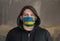 Man Wearing a hood and a Rwanda flag Mask to Protect him virus