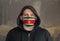 Man Wearing a hood and a Suriname flag Mask to Protect him virus