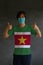 Man wearing hygienic mask and wearing Suriname flag colored shirt with thumbs up on both hands