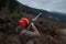 A man wearing a jacket, blaze orange hat and ear protection holds an old double barrel shotgun, aiming and shooting at orange clay