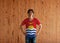 Man wearing Kiribati flag color shirt and standing with akimbo on the wooden wall background