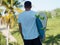 Man wearing a mint color t shirt, with Surfboard, tropical background.