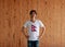 Man wearing Nepal flag on white shirt and standing with akimbo on the wooden wall background