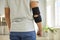 Man wearing an orthopedic elbow support brace for easing pain in his injured elbow