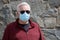 Man wearing a paper mask on his face. A man wears a Medical Face Mask to help avoid contracting Coronavirus aka Covid-19. Covid-19