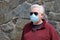 Man wearing a paper mask on his face. A man wears a Medical Face Mask to help avoid contracting Coronavirus aka Covid-19. Covid-19