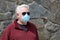 Man wearing a paper mask on his face. A man wears a Medical Face Mask to help avoid contracting Coronavirus aka Covid-19. Covid-19