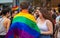 Man wearing pride flag of LGBTQ while celebrating