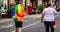 Man wearing pride flag of LGBTQ walking