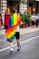 Man wearing pride flag of LGBTQ walking