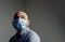 Man wearing protective standard FFP1 antiviral protective face mask looking up