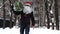 Man wearing a red Santa hat and a white beard carries home a Christmas tree packed in a grid