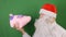 Man wearing Santa Claus`s cap talking with a piggy or mumps, New year 2019 and christmas, on green Chroma key