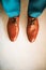 Man wearing shoes on gray background. Clothing concept, groom getting ready before ceremony. Body detail of businessman.