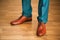 Man wearing shoes on wooden floor. Clothing concept, groom getting ready before ceremony. Body detail of businessman.