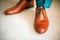 Man wearing shoes on wooden floor. Clothing concept, groom getting ready before ceremony. Body detail of businessman.