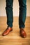 Man wearing shoes on wooden floor. Clothing concept, groom getting ready before ceremony. Body detail of businessman.