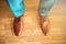 Man wearing shoes on wooden floor. Clothing concept, groom getting ready before ceremony. Body detail of businessman