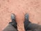 A man wearing steel toe shoes and standing in a mud.