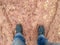 A man wearing steel toe shoes and standing in mud.