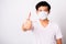 Man wearing surgical hygienic protective cloth face mask against coronavirus he show finger thumb