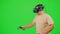 The man wearing VR headset dancing in virtual reality. The man on chroma key green screen background. Guy in virtual