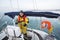 Man Wearing Waterproof Jacket While Steering Yacht In Sea