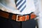 Man wears belt. Young businessman in casual suit with accessories. Fashion and clothing concept. Groom getting ready in