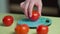 Man weighing fresh tomatoes on a kitchen electronic scale, close-up