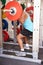 Man weightliftingï¿½barbells at a squat rack in a gym