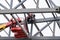 Man welder working on a crane performs high-rise work on welding metal structures of tower at a height