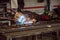 Man welding creating sparks, wearing safety equipment