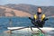 Man in wetsuit sitting on surfing board in lotus position and doing meditation zen exercise. Windsurfing and life balance concept