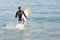 Man in wetsuit with a surfboard on a sunny day