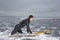 Man In Wetsuit Surfing At Beach