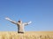 Man in Wheat Field With Arms Outstretched