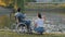 Man in a wheelchair and nurse feeding ducks