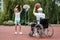 A man in a wheelchair plays basketball with his son on the sports ground. Disabled parent, happy childhood, disabled person