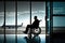 man in wheelchair, waiting for flight, with view of busy airport terminal