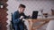 Man in wheelchair working with laptop at home. Adult disabled male working studying on laptop