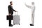 Man in a white decontamination suit gesturing stop to a businessman with a suitcase