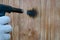 A man in white gloves performs firing of wooden panels with a gas burner. Treatment of the wooden surface fire.